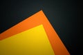 Yellow and orange paper on a black background. Royalty Free Stock Photo