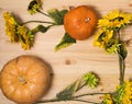 Yellow-orange pumpkins and sunflowers on a light wooden surface, Halloween and autumn harvest concept, farm product, vegetable