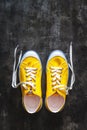 yellow-orange sneakers with untied laces on a dark concrete background. Copy space. View from above Royalty Free Stock Photo