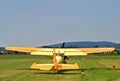 Yellow orange sport airplane during take off on runway on sport airfield