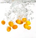 Yellow oranges falling into water