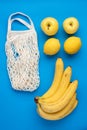 Yellow organic fruits banana, apple, lemon and zero waste mesh shopping bag