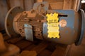 Yellow out of service tag attached on faulty damage defect of electric power motor Royalty Free Stock Photo