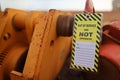 Yellow out of service warning tag sign attached on faulty damage defect of heavy duty lifting beam trolley Royalty Free Stock Photo