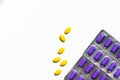 Yellow oval tablet pills on white background and purple caplets pills in blister pack. Mild to moderate pain management.