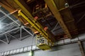 Yellow overhead crane with linear traverse and hooks in engineering plant shop Royalty Free Stock Photo