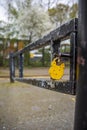Yellow Padlock on the barrier post in a restricted area in London.
