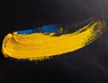 yellow paint brush stroke on black syrface - template with copy space