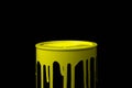 Yellow paint flowing down on wall of metal bucket. Isolated over black Royalty Free Stock Photo