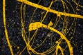 Yellow paint spilled onto the dark asphalt. Abstract composition with chaotic lines and drops. Flat frame Royalty Free Stock Photo