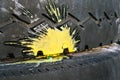 Yellow paint splash from a crashed paintball on an old car tire with a zigzag tread pattern. Selective focus Royalty Free Stock Photo