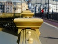 Yellow painted cast iron bridge railing in diminishing perspective with pedestrian