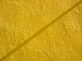 Yellow painted cement wall with line shadow. Abstract grunge texture background. Copy space, empty template for text Royalty Free Stock Photo