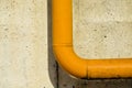 Yellow metal pipe on unplastered concrete