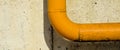 Yellow metal pipe on unplastered concrete