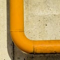 Yellow metal pipe on unplastered concrete