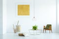 Yellow painting and green wooden armchair in white living room i