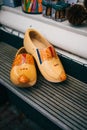 Yellow pair of traditional Dutch wooden shoes on a wooden bench Royalty Free Stock Photo