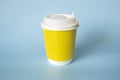 yellow paper coffee mug on a blue background. Empty space for text and design on a cup of coffee. The form for the name of the Royalty Free Stock Photo