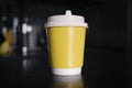 yellow paper coffee mug on a dark background. Empty space for text and design. The form for the name of the coffee or company or Royalty Free Stock Photo