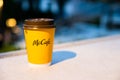 A yellow, paper glass from McDonald's in the evening light.