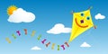 Yellow paper kite with happy face and tail with colorful bows flying in a blue sky with clouds Royalty Free Stock Photo