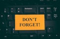 Yellow paper note on black keyboard with writing Don`t Forget! Royalty Free Stock Photo