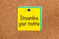 Yellow paper note with words Streamline Your Routine on a corkboard Royalty Free Stock Photo