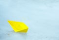 Yellow paper ship in a puddle