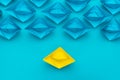 Yellow paper ship stand out of the crowd concept over blue background