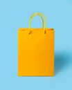 Yellow paper shopping bag on blue background. Shopping sale delivery concept. Packaging gift