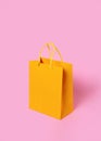 Yellow paper shopping bag on pink background. Shopping sale delivery concept. Packaging gift