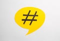 Yellow paper speech bubble with hashtag symbol on white background, top view Royalty Free Stock Photo