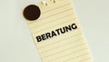 Yellow paper with text Beratung on the white fridge