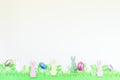 Yellow paper texture with green felt grass, bunny and colorful eggs, Easter background, horizontal, copy space Royalty Free Stock Photo