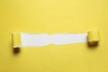 Yellow paper with torn hole on white background, top view. Space for text Royalty Free Stock Photo