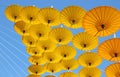 Yellow paper umbrella floating in the blue sky. Royalty Free Stock Photo