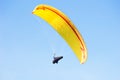 Yellow paraglider in blue sky