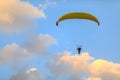 Yellow paraglider with a motor at sunset on a background of clouds view from the back