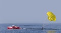 The yellow parasail wing glides through the water pulled by a powerboat. Guy takes a selfie Royalty Free Stock Photo