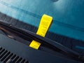 Yellow parking fine paper on the front glass windshield in German city