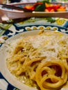 Yellow pasta with cheese on a light round plate