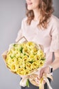 Yellow pastel color tulips in woman hand. Young beautiful woman holding a spring bouquet. Bunch of fresh cut spring