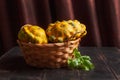 Yellow patissons or squash in a wicker basket and a basil leaf on a brown wooden background Royalty Free Stock Photo