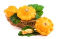 Yellow pattypan squash with leaf and flower in a wicker basket isolated on white background