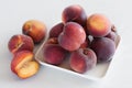 Yellow peaches on white plate, on white table Royalty Free Stock Photo