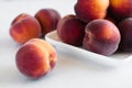 Yellow peaches on white plate, on white table Royalty Free Stock Photo