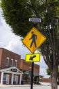 A yellow pedestrian walking sign and a yellow down arrow sign