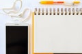 Yellow pen on a notebook and cell phone with earphone on white b Royalty Free Stock Photo