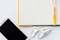 Yellow pen on a notebook and cell phone with earphone. Royalty Free Stock Photo